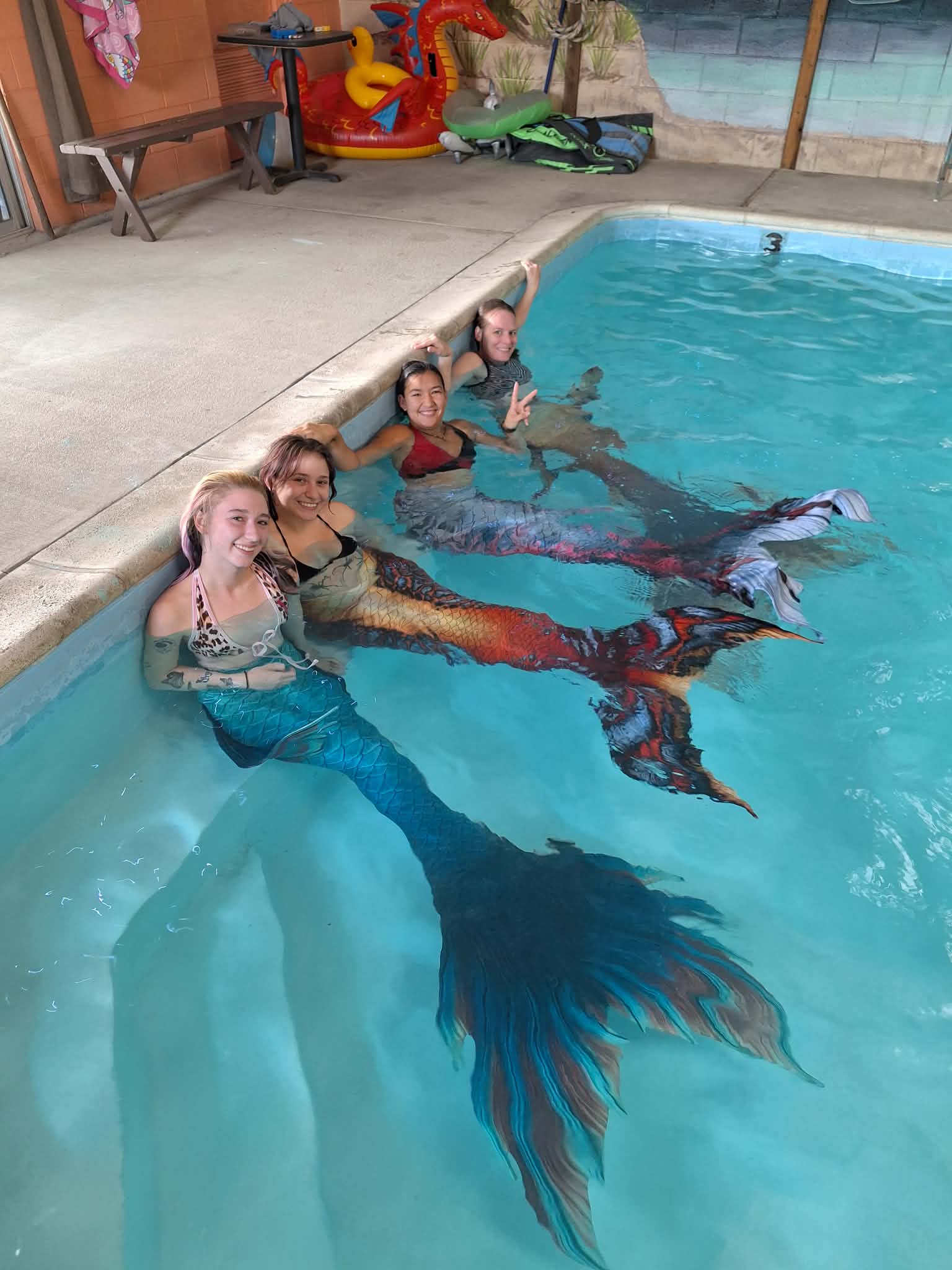 4 Mermaids sitting in a pool